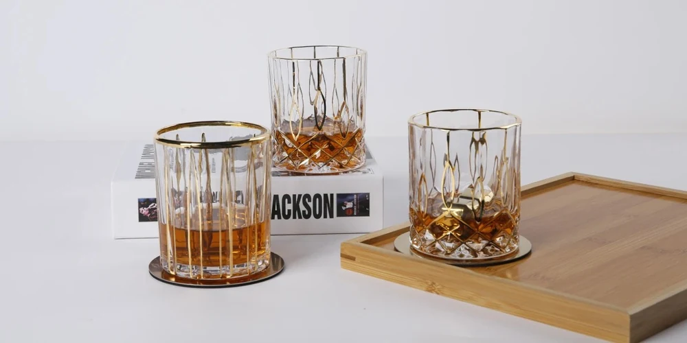 Hand-applied 24K real gold rim and facet detailing on luxury crystal whiskey glasses with bamboo tray