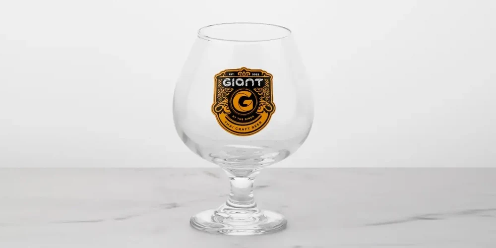 Multi-color high-temperature water slide decal on craft beer snifter glass with gold and black crest