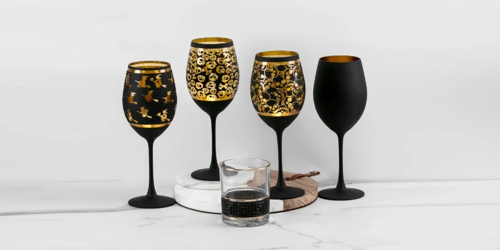 Mixed finish combining matte black exterior spray coating, golden interior foil, and laser cutouts on wine glasses