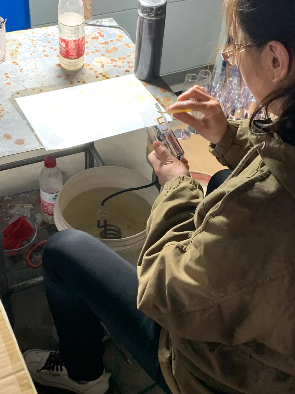 Artisan applying high-temperature water slide decals with gold foil alignment and bubble scraping